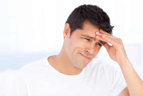 Man holding his head due to a headache