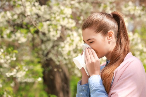 Women blowing her nose with a tissue