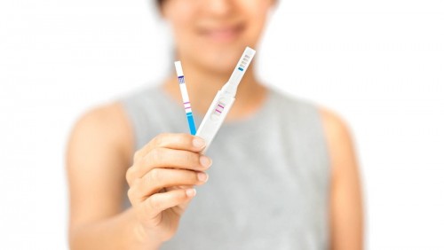 Women holding pregnancy test results