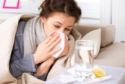 Girl with tissue on her nose suffering from influenza