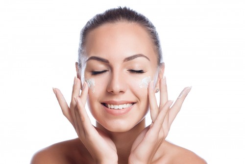 Smiling women applying face wash